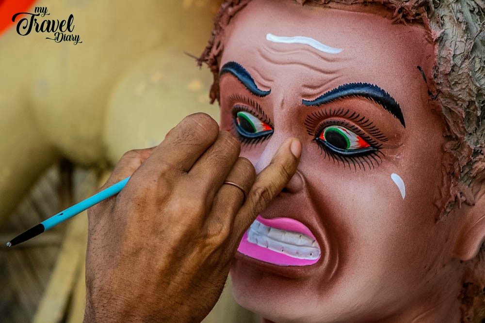 Artist giving finishing touches to the clay idol