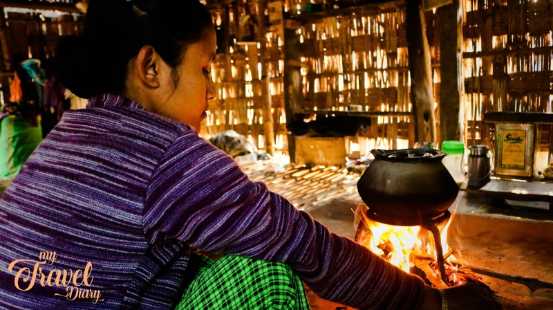 A young Mishing Tribal woman is cooking in her kitchen in Majuli