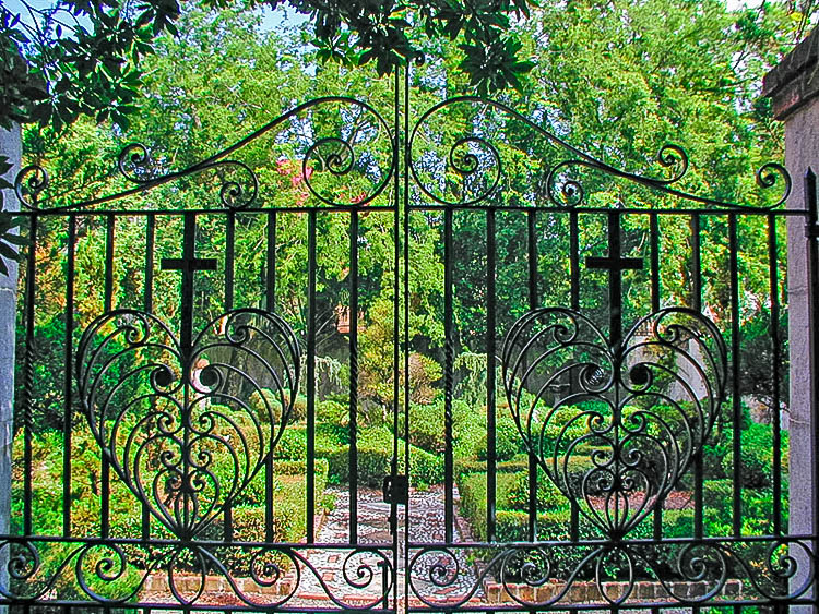 Secret garden in Charleston seen through iron gate